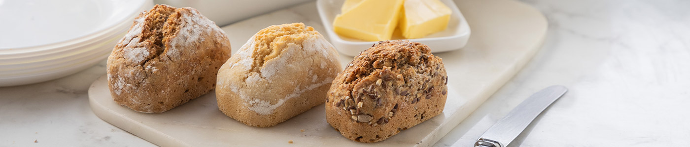 White, Brown and Seeded Penny Loaves on board with butter